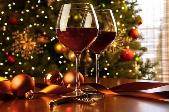 Red wine on table Christmas tree in background